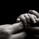 Baby hand holding mother’s hands