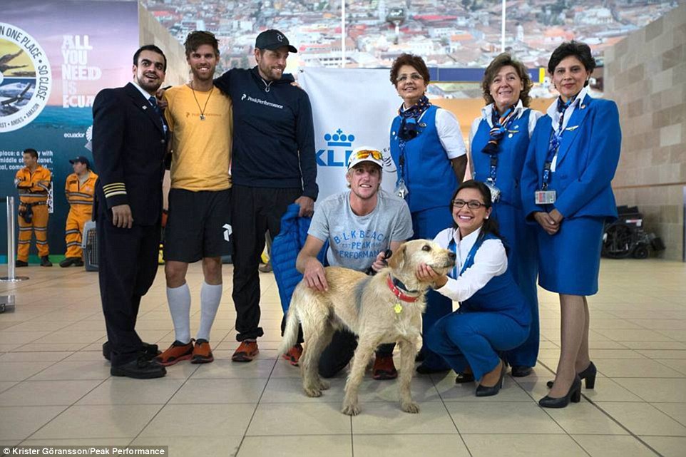Pose: Members of the team stand alongside with flight attendants and a pilot as they prepare to take Arthur home to his new family