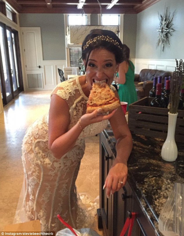 Another bride was happy to be snapped tucking enthusiastically into a large slice of pizza