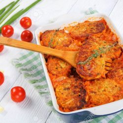 94230658-couscous-fish-patties-with-onion-carrots-and-tomato-sauce-in-baking-dish-with-green-onion-and-tomato